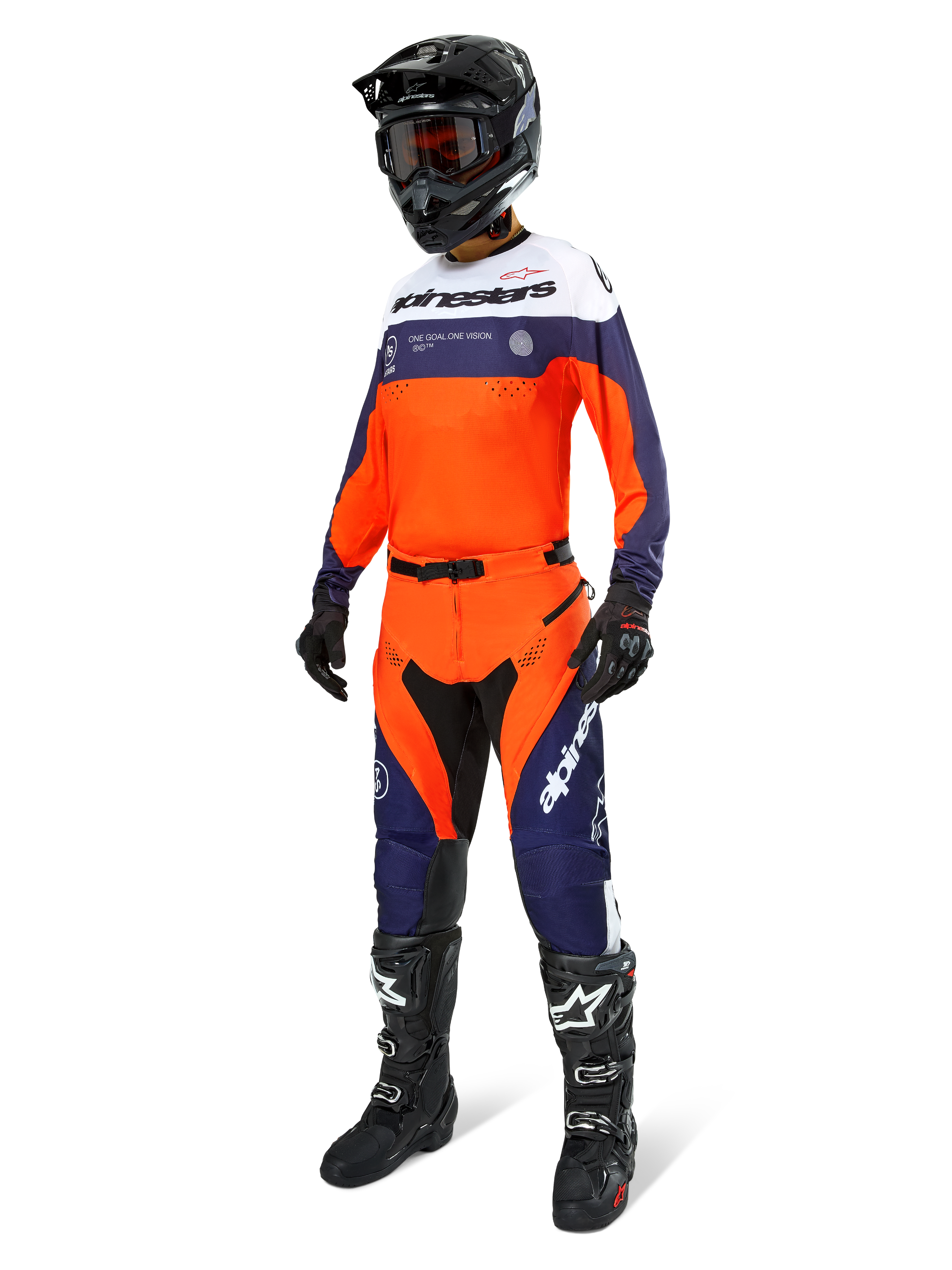 Alpinestars Pro-Dura broek, motorcross- en endurobroek, marineblauw, fel oranje en wit, gedragen als onderdeel van een complete race-uitrusting met bijpassende jersey, zwarte helm en zwarte laarzen, voorzien van duurzame panelen en opvallende branding voor off-road prestaties.
