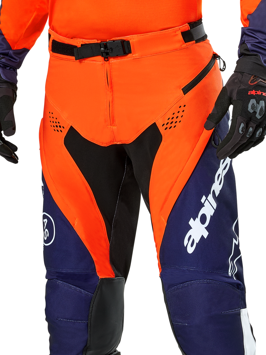 Alpinestars Pro-Dura broek, enduro motorbroek, marineblauw, feloranje en wit, detailweergave van de taille met SX2 magnetische gesp en ventilatieopeningen met rits op de dijen, duurzaam ripstop-materiaal met opvallende branding, gedragen met bijpassende uitrusting