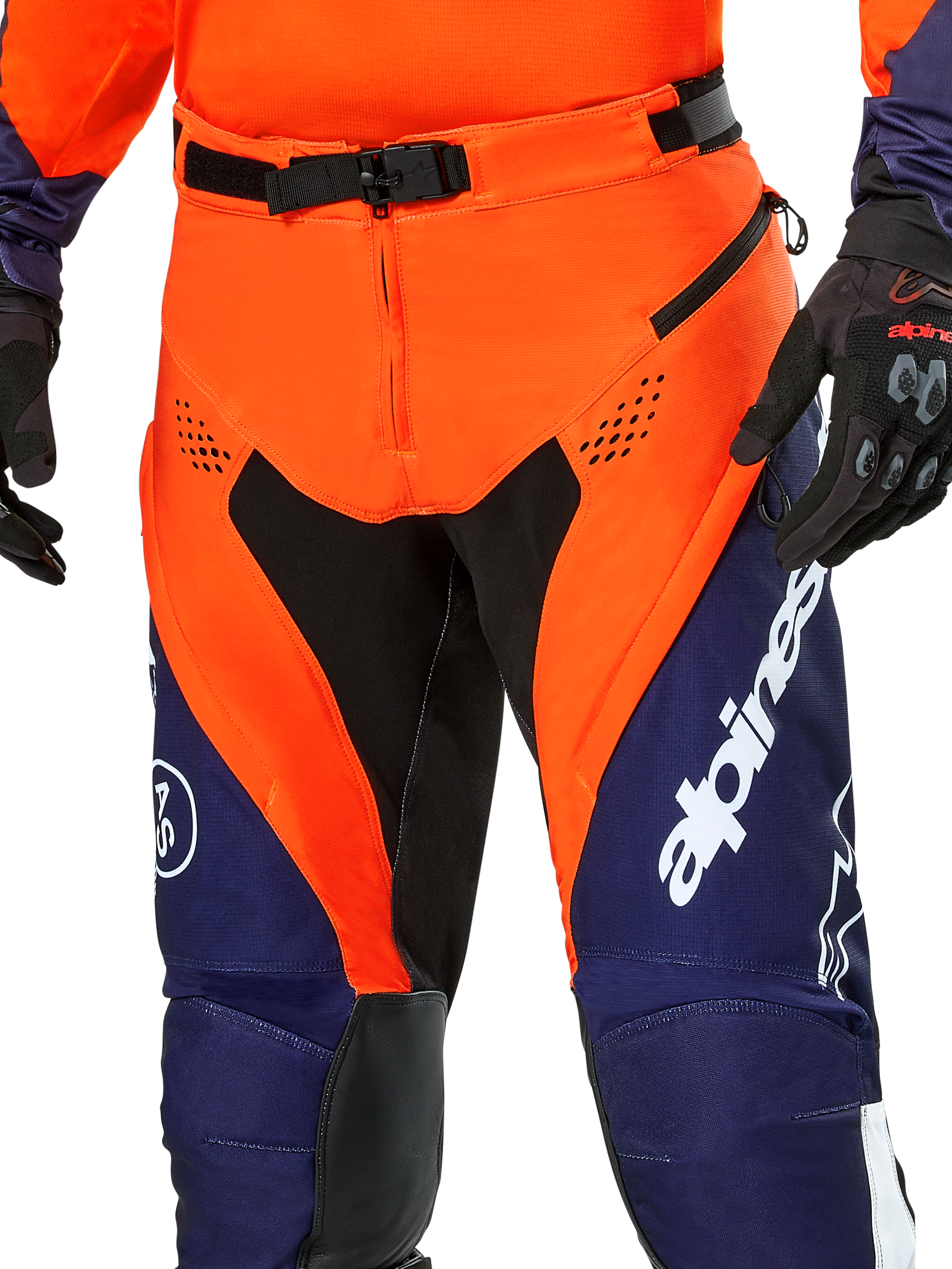 Alpinestars Pro-Dura broek, enduro motorbroek, marineblauw, feloranje en wit, detailweergave van de taille met SX2 magnetische gesp en ventilatieopeningen met rits op de dijen, duurzaam ripstop-materiaal met opvallende branding, gedragen met bijpassende uitrusting