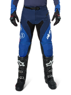 Alpinestars Pro-Dura broek, motorcrossbroek, marineblauw en felblauw met witte accenten, vooraanzicht gedragen met zwarte laarzen en handschoenen, technisch ontwerp voor enduro en off-road rijden