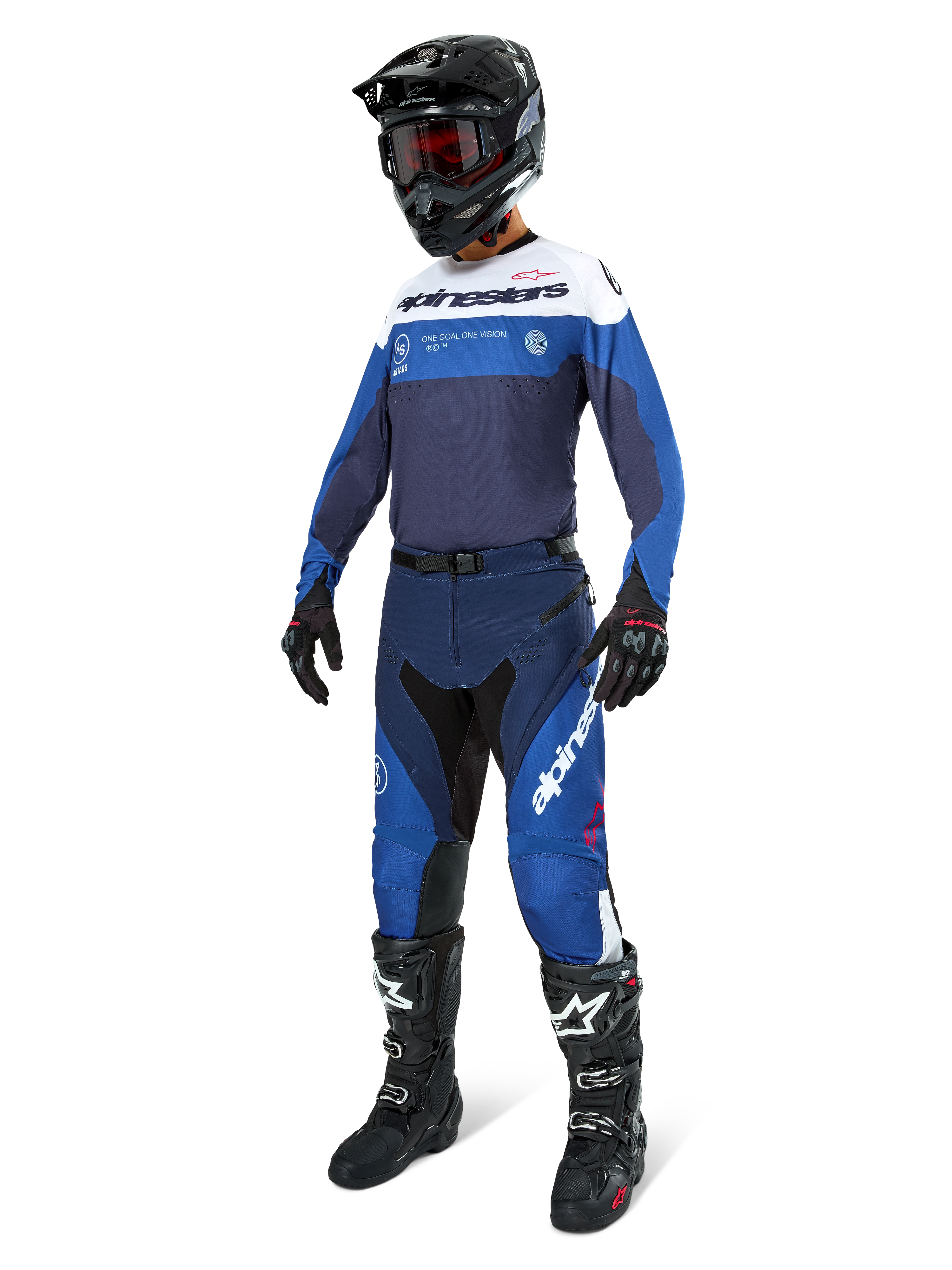 Motocross-rijder in Alpinestars Pro-Dura broek in marineblauw, felblauw en wit, gecombineerd met een bijpassende jersey met lange mouwen, zwarte helm met rode bril, zwarte handschoenen en zwart-witte laarzen, gecoördineerde outfit voor enduro en off-road racing.