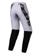 Alpinestars 2025 Supertech Maker broek, motorcross broek, zilver met zwart, achteraanzicht met grote zwarte Alpinestars-branding op de zijkant, zwarte panelen op de onderbenen en kleine rode sterlogo's op de tailleband, ontworpen voor professionele off-road prestaties