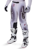 Alpinestars 2025 Supertech Maker crossbroek, motorcross broek, zilver en zwart, met grote sterlogo's en rode belettering, getoond met bijpassende witte laarzen en handschoenen