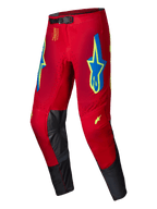 Alpinestars 2025 Supertech Maker Pants, Motocross Pants, Bright Red with Yellow Fluo and Blue accents, featuring large star logos on the thighs and black leather inner knee panels, magnetic waist closure, professional off-road racing gear
