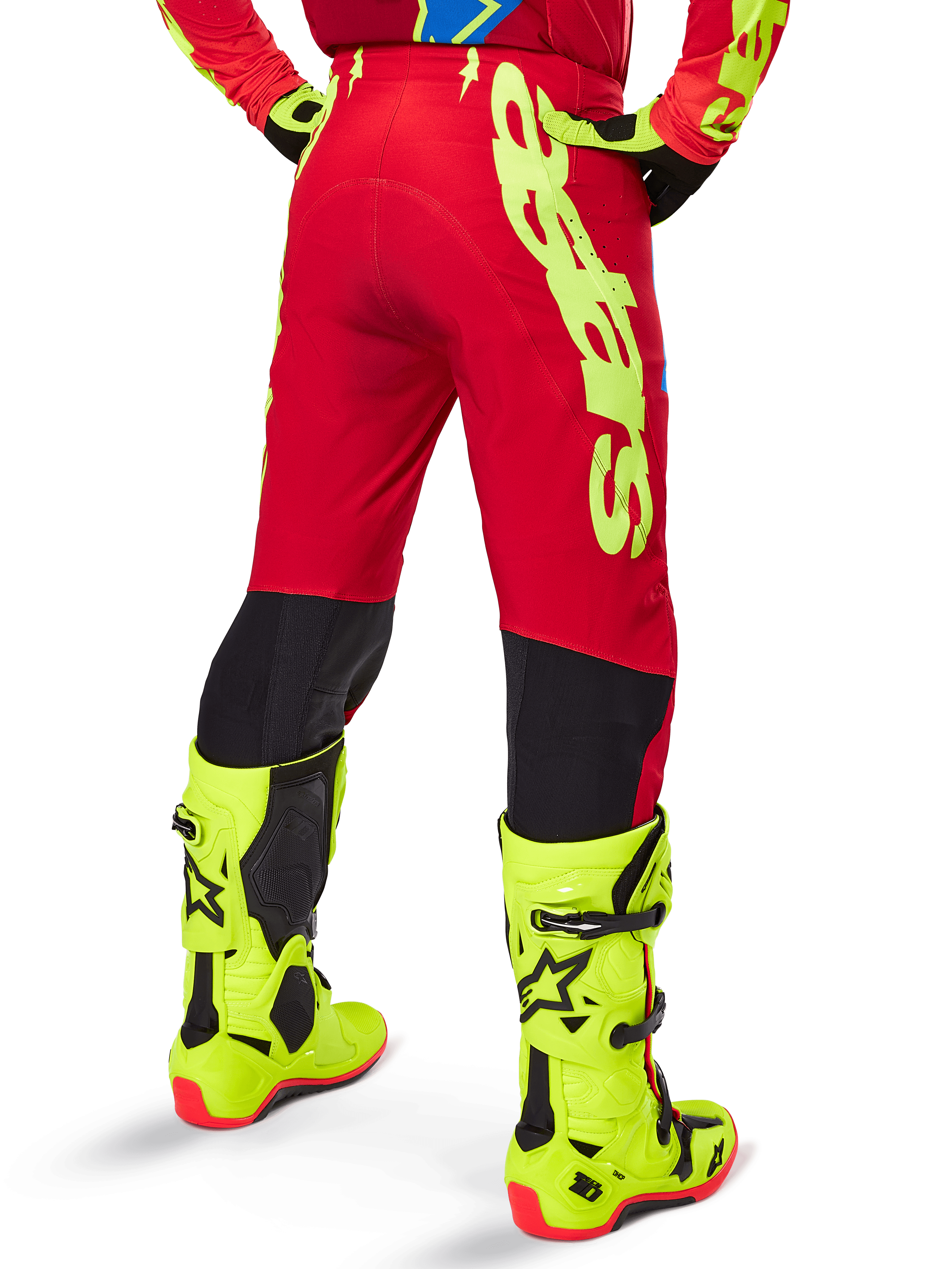 Alpinestars 2025 Supertech Maker crossbroek, motorcross broek, felrood en fluogeel, achteraanzicht, met opvallende gele branding, zwarte panelen achter de knieën, gedragen met bijpassende fluogele laarzen, ontworpen voor professionele off-road prestaties