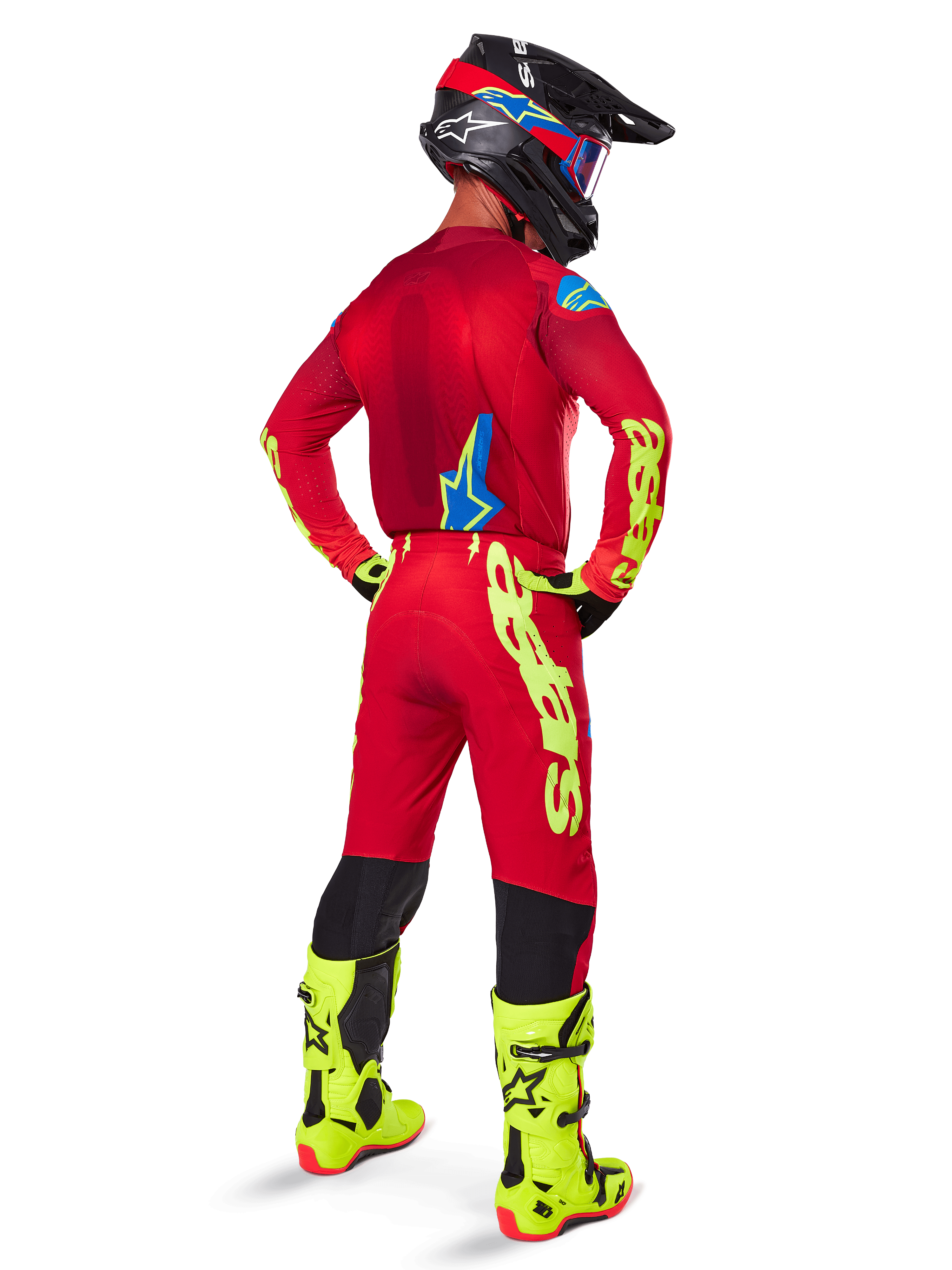 Alpinestars 2025 Supertech Maker Pants, Motocross Pants, Bright Red and Yellow Fluo, seen from behind on a rider wearing a matching red jersey, fluorescent yellow boots, and black helmet, featuring large yellow Alpinestars branding on the leg.