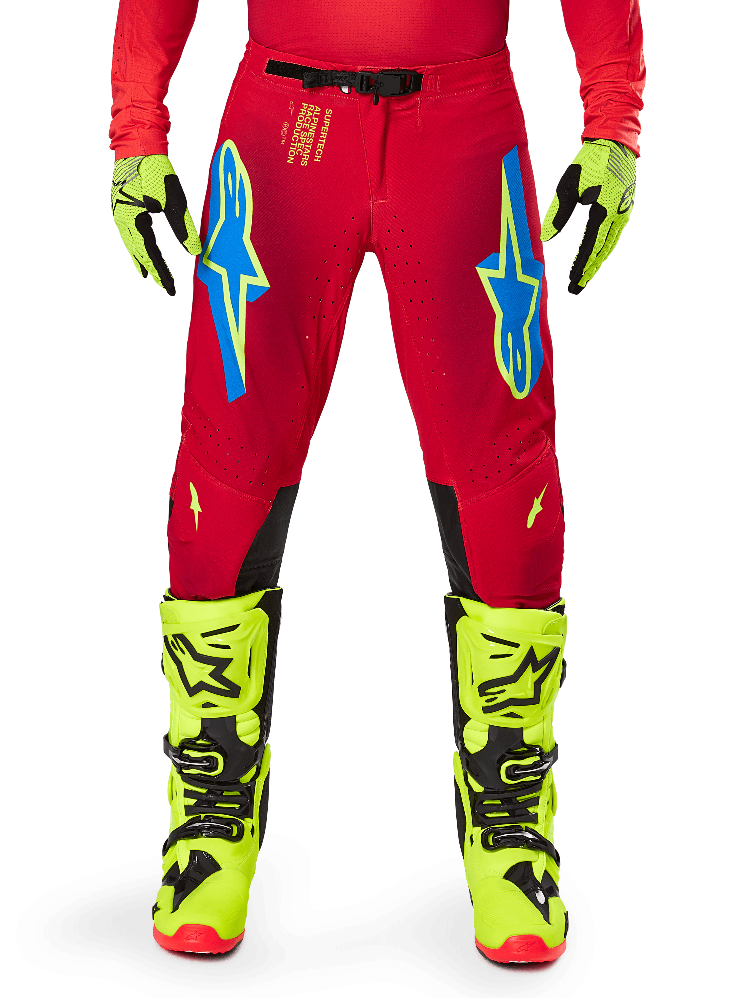 Alpinestars 2025 Supertech Maker broek, motorcrossbroek, felrood en fluogeel, met blauwe Astars-logo's op de dijen, geventileerde perforaties en zwarte panelen aan de binnenzijde van de knie, gedragen met bijpassende fluogele laarzen en handschoenen