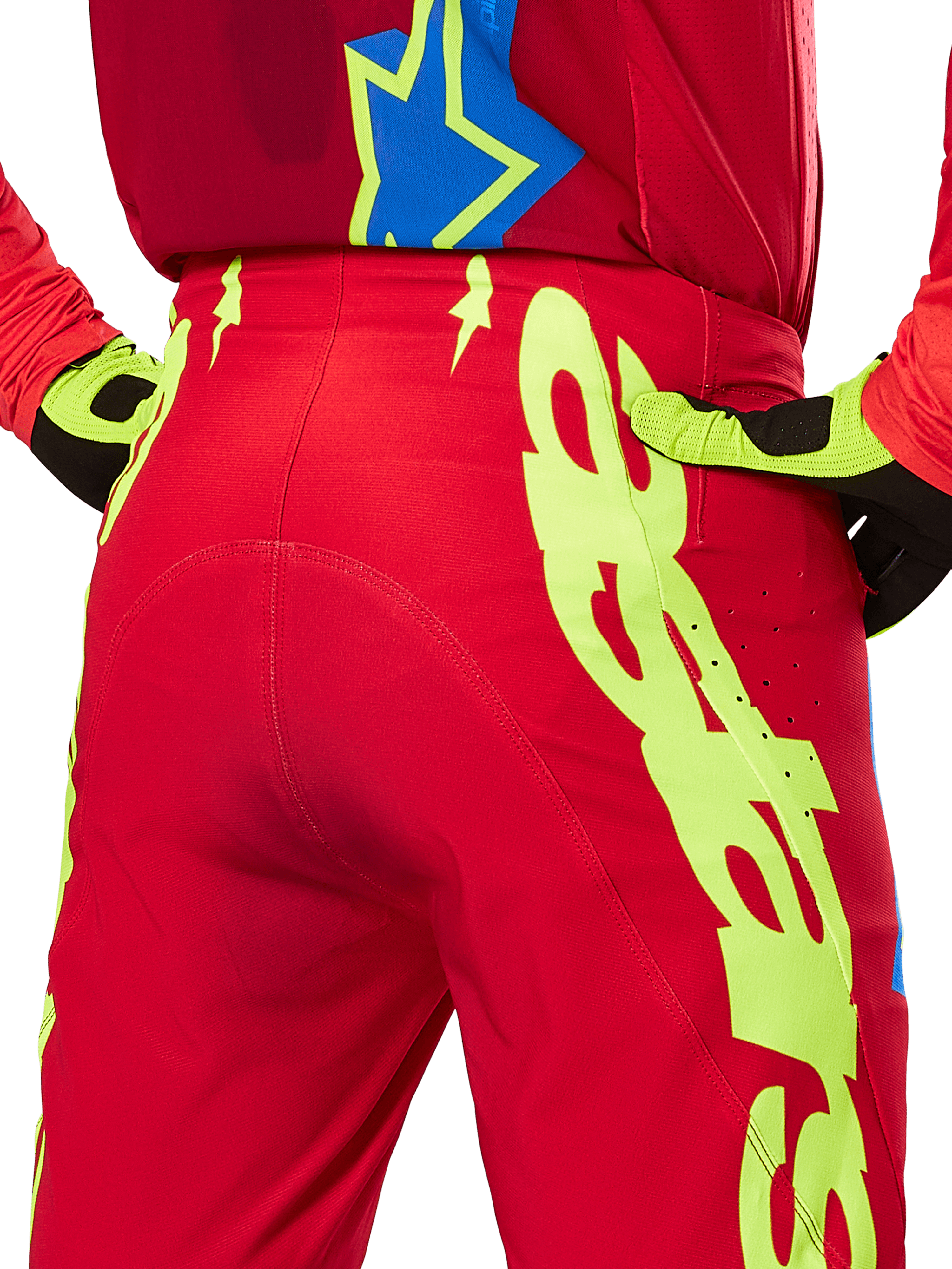 Alpinestars 2025 Supertech Maker crossbroek, motorcross broek, felrood en fluogeel, achteraanzicht met grote gele graphics op de pijpen en bijpassende fluogele en zwarte handschoenen, professionele off-road race-uitrusting