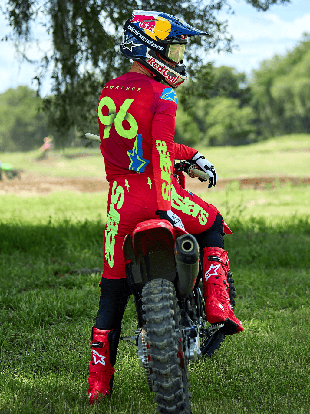 Motorcrosser die de Alpinestars 2025 Supertech Maker-set in Bright Red en Yellow Fluo draagt, zittend op een rode crossmotor, met rugnummer 96, bijpassende rode laarzen en helm, professionele race-uitrusting voor off-road prestaties