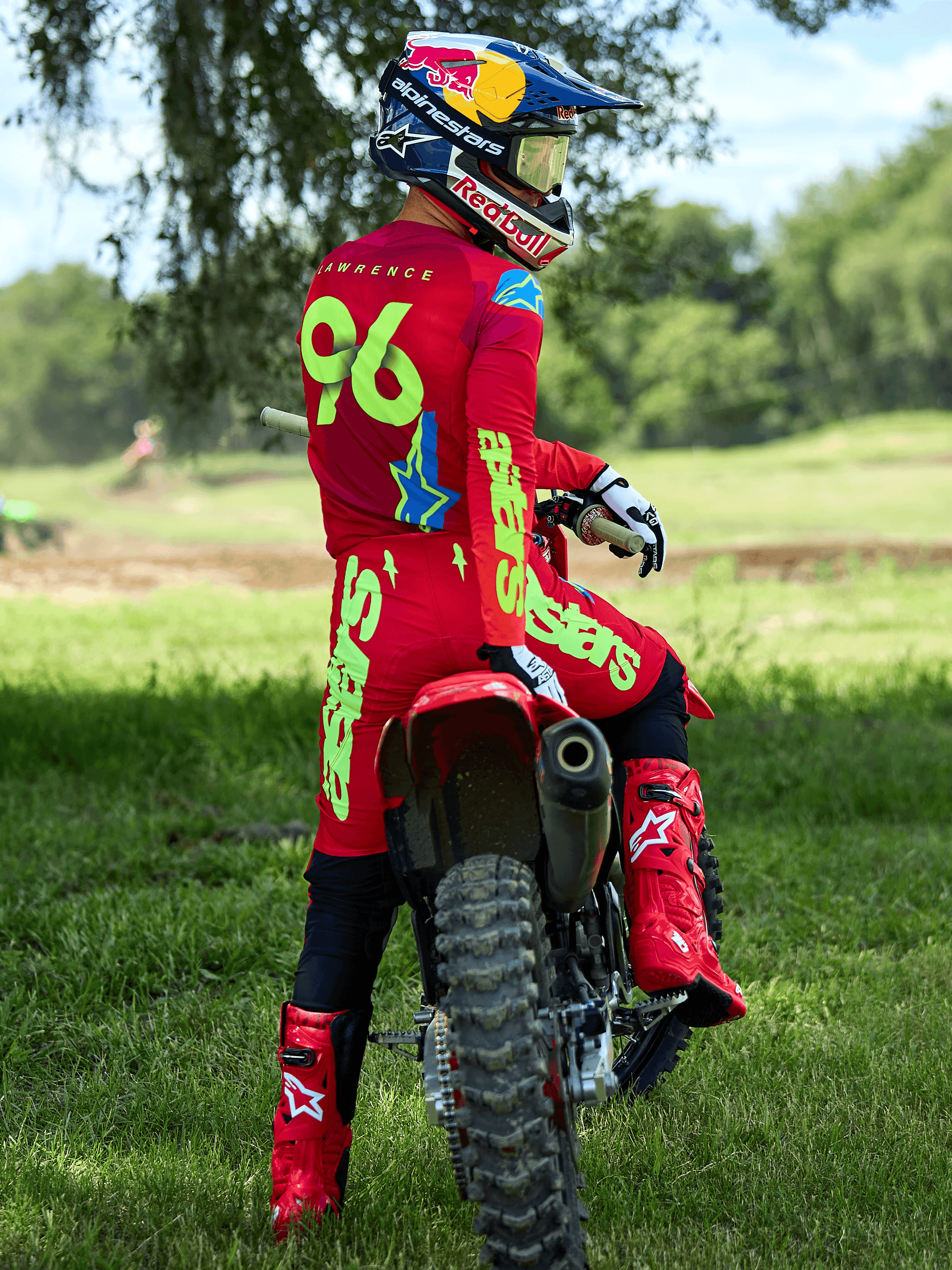 Alpinestars 2025 Supertech Maker broek in Bright Red en Yellow Fluo, motorcross-rijder op een rode crossmotor, bijpassende rode jersey met '96' en 'LAWRENCE' op de rug, rode motorcrosslaarzen en Red Bull-helm, professionele off-road race-uitrusting