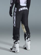 Alpinestars 2026 Racer Air Riway Pants, Motocross Pants, Black and White, rear view with large white Astars branding on seat and legs, tan leather inner knee panels, worn with white and black Tech 7 boots, premium off-road racing apparel.