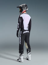 Motocross rider seen from the back wearing Alpinestars 2026 Racer Air Riway Pants in Black and White, paired with a matching ventilated jersey, black and white helmet, and white motocross boots, featuring prominent white 'astars' branding on the seat.