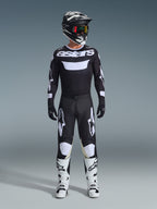 Alpinestars 2026 Racer Air Riway Gear Set, complete motocross outfit, black and white, featuring a black jersey with white 'astars' branding, matching pants with white knee panels, white boots with black buckles, and a black helmet with red-tinted goggles, professional off-road racing gear.