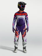 Alpinestars Supertech Dyna broek en gear set, heren motocross-outfit, paars en roze fluo met jersey en witte motorlaarzen.