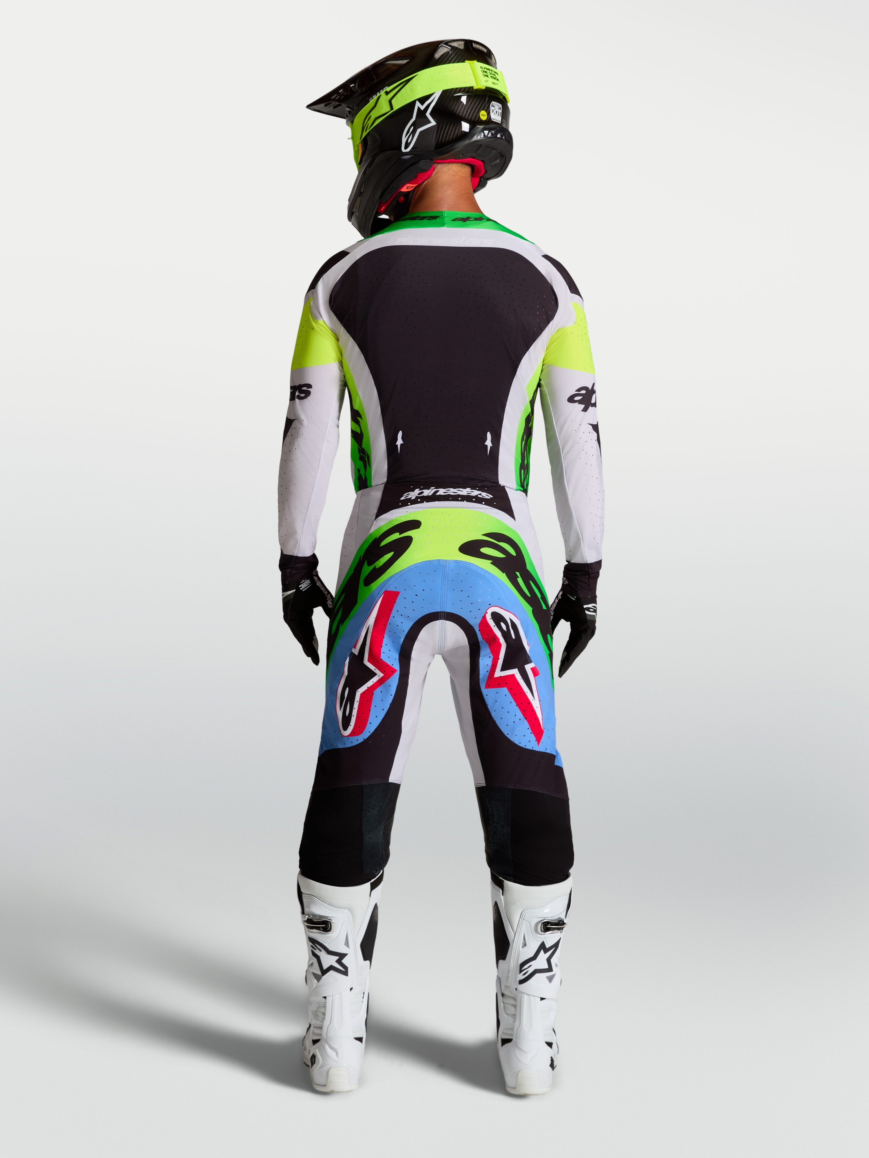 Alpinestars Supertech Dyna broek, motocrossbroek, lichtlila en fluorgroen, achteraanzicht van rijder in race-uitrusting.