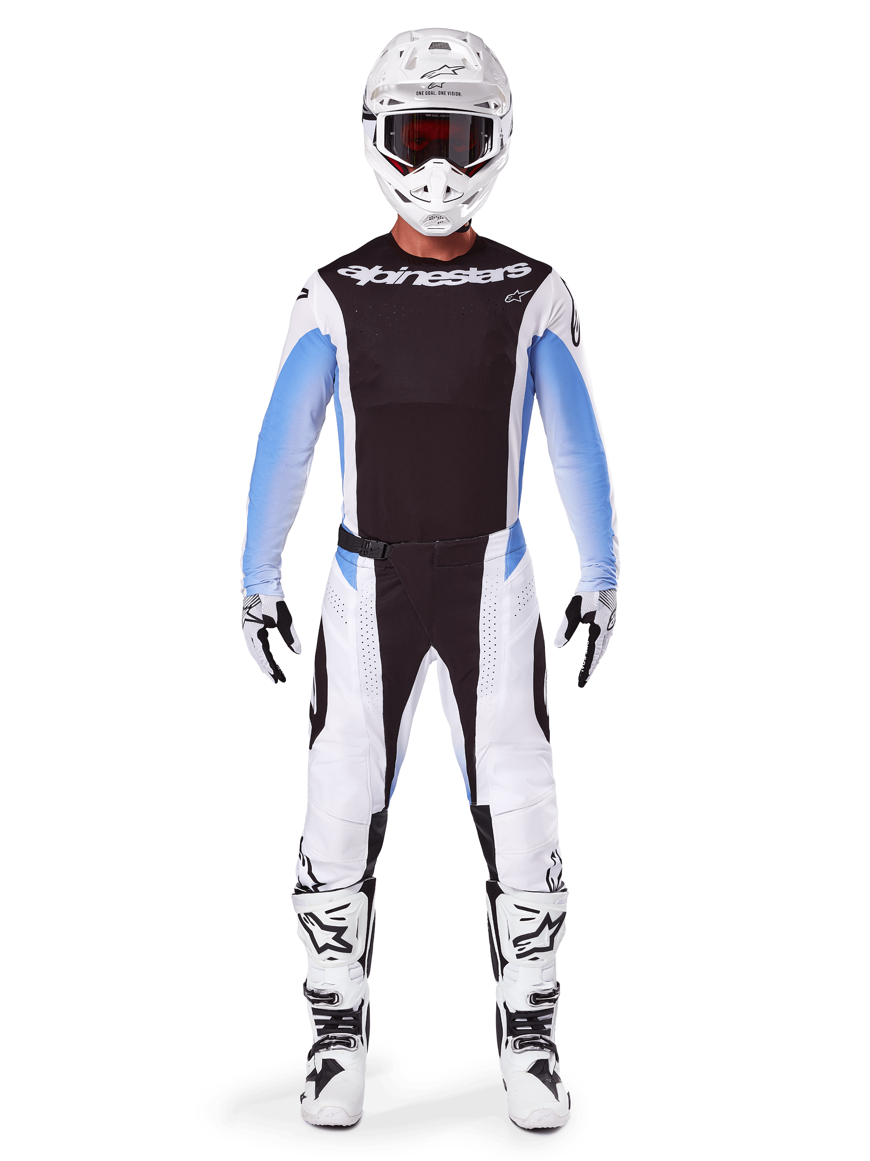 Motocrossrijder in Alpinestars 2025 Techstar Melt broek, motorcrossbroek, zwart en blauw, wit en zwart multi-panel ontwerp met blauwe heupaccenten, gedragen met bijpassende witte jersey, witte helm, witte handschoenen en laarzen voor een complete off-road race-uitrusting