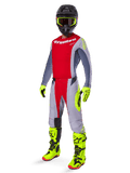 Motorcrossrijder in de Alpinestars 2025 Techstar Melt Gear Set, rood en grijs jersey en broek, opvallende neongele handschoenen en laarzen, zwarte helm, complete off-road race-uitrusting