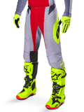 Alpinestars 2025 Techstar Melt crossbroek, motorcross broek, helderrood en grijs, met neongele graphics aan de zijkant en zwarte kniepanelen, gecombineerd met bijpassende neongele laarzen en handschoenen, ontworpen voor competitieve off-road prestaties