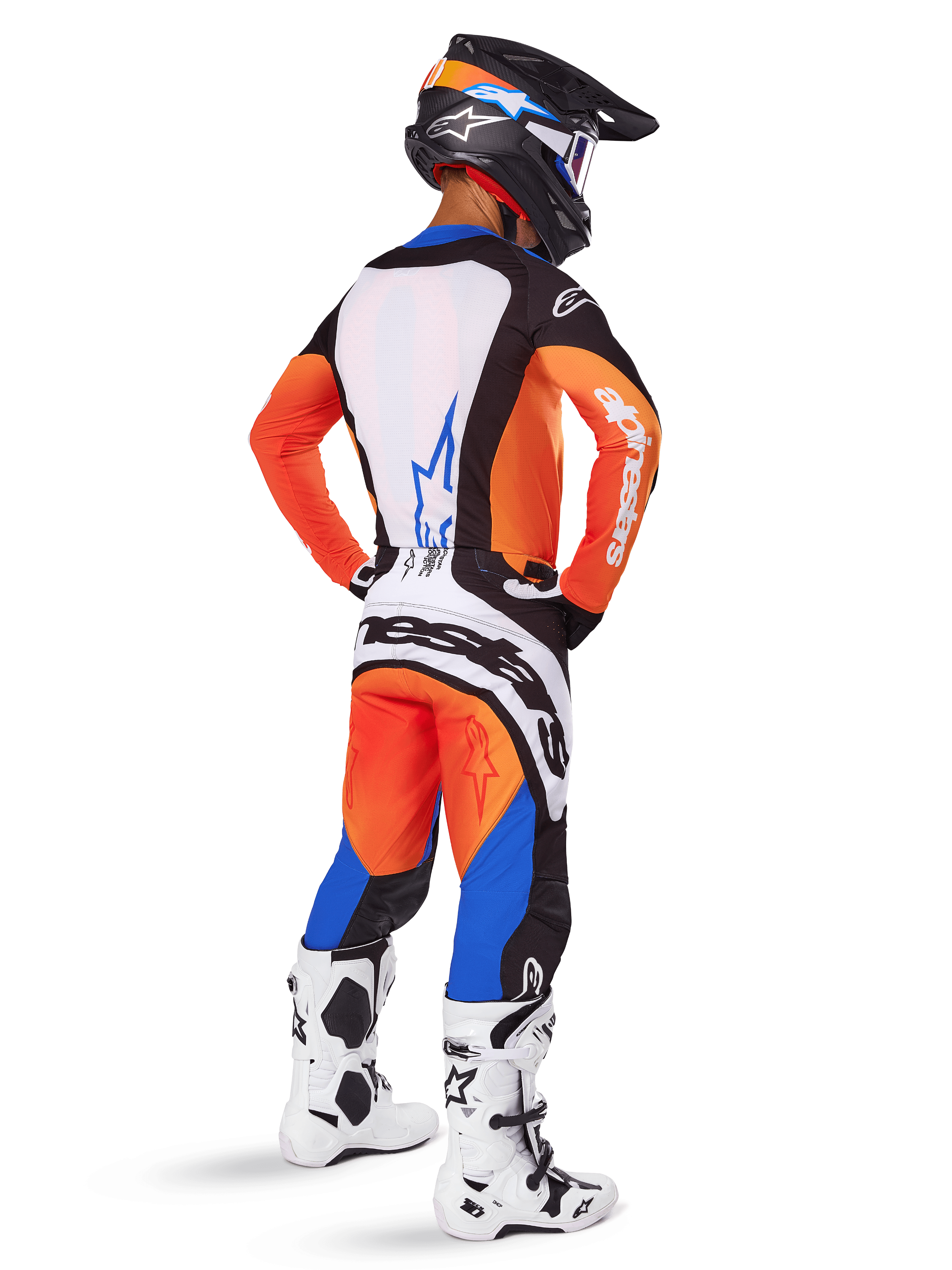 Motorcrosser van achteren gezien in de Alpinestars 2025 Techstar Melt Gear Set, oranje en blauwe jersey met wit rugpaneel en bijpassende broek, met grote witte merkdetails, zwarte motorcrosshelm en witte racelaarzen.