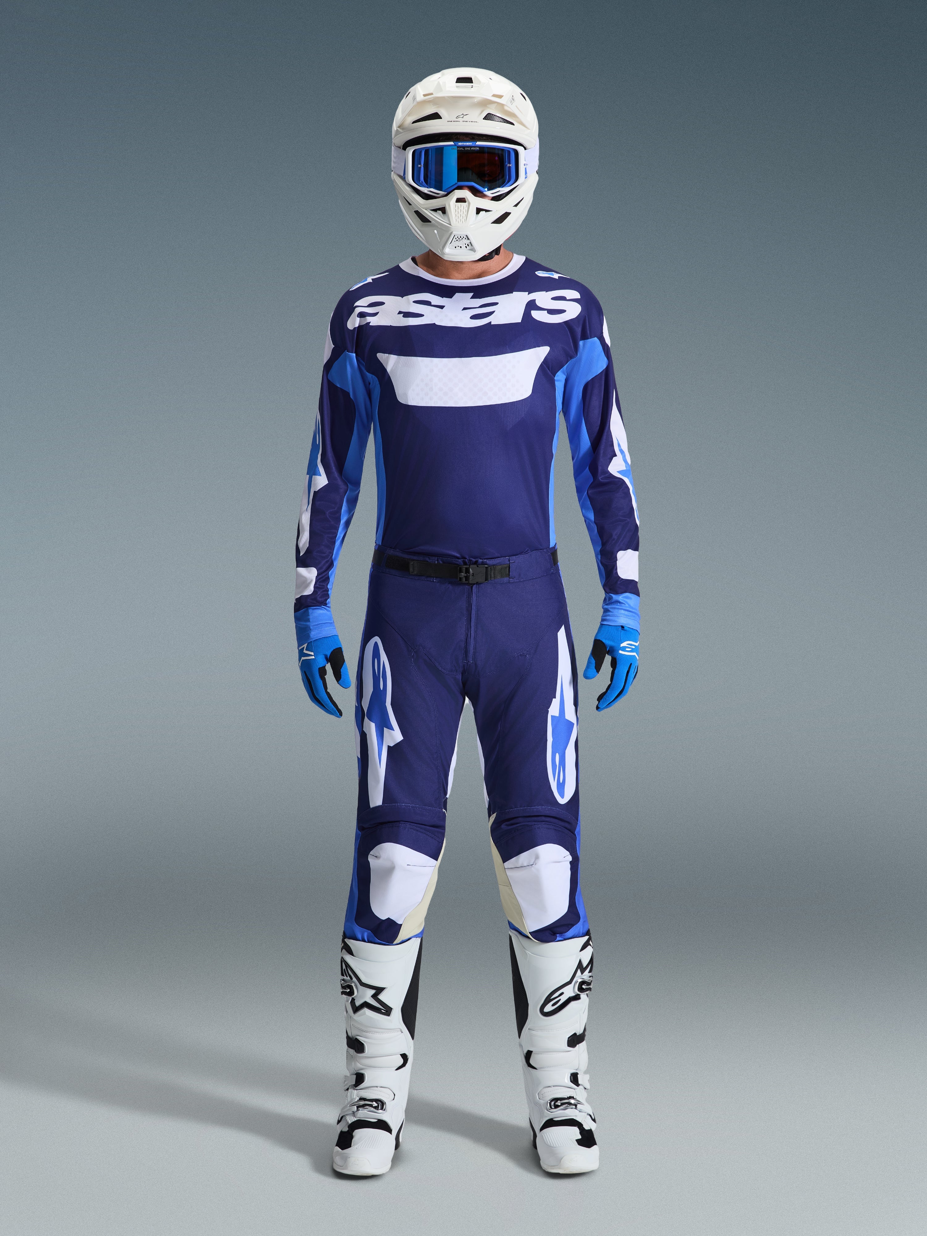 Alpinestars 2026 Racer Riway Gear Set, volledige motorcross-uitrusting, marineblauwe en lichtblauwe jersey met witte 'astars'-tekst, bijpassende broek met witte accenten, witte helm met blauwe crossbril en witte off-road laarzen.