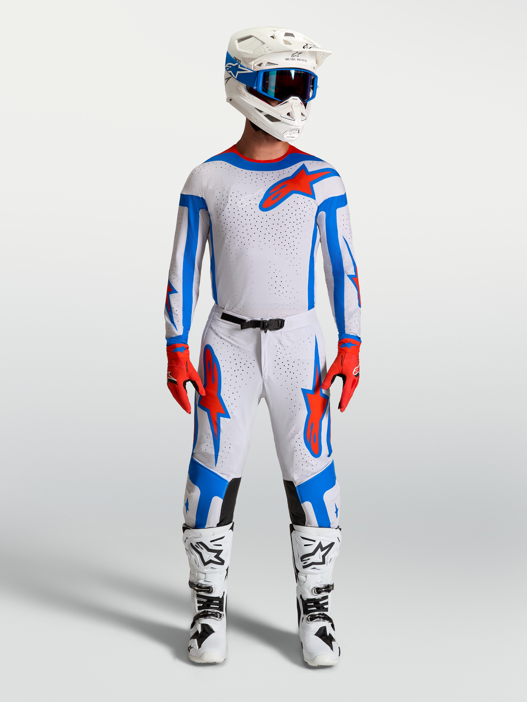 Alpinestars Supertech Vesta motorcrossset in wit, lichtlila en rood, met jersey, broek en motorlaarzen voor off-road racing.
