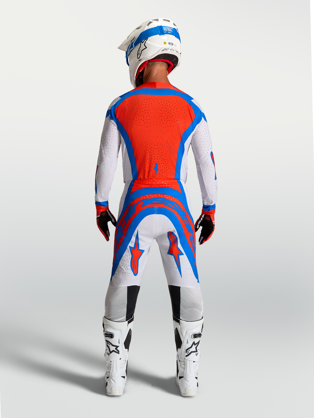 Alpinestars Supertech Vesta motocrossbroek in licht lila en rood, achteraanzicht op model met atletische racepasvorm.