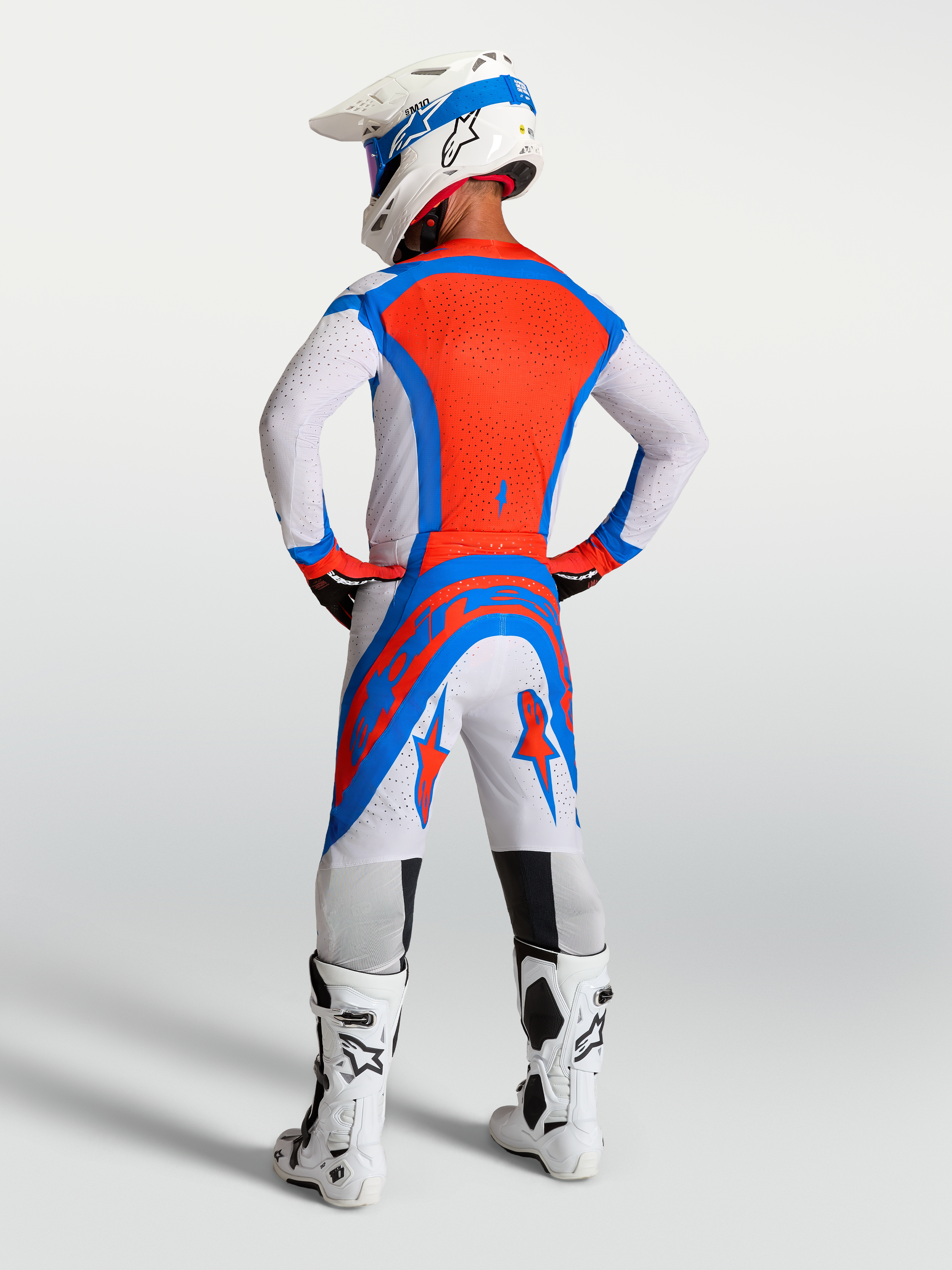 Alpinestars Supertech Vesta broek, rode en witte motocrossbroek met atletische pasvorm en ventilatie, achteraanzicht op model.