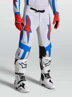 Alpinestars Supertech Vesta broek, motocrossbroek in wit en rood met blauwe ster-graphics, atletische racepasvorm.