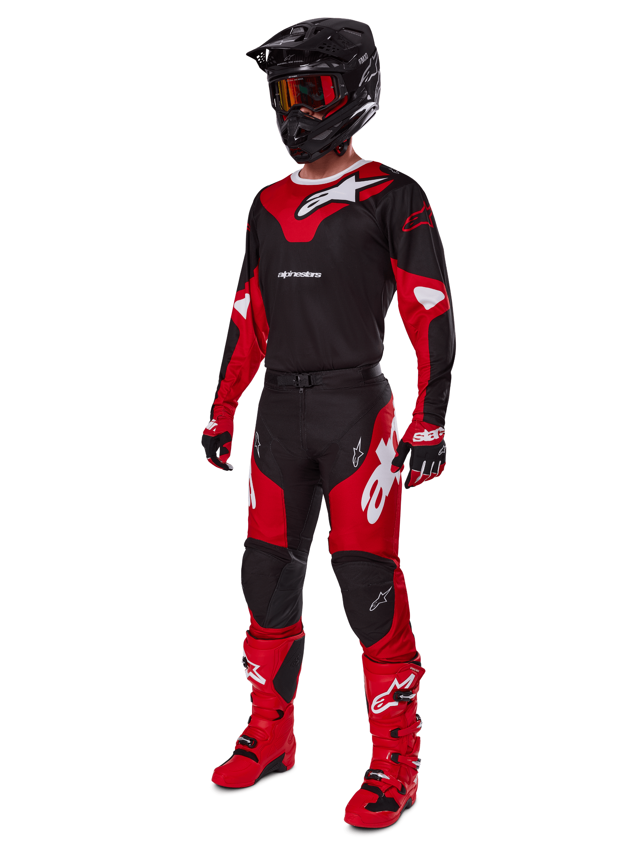 Alpinestars 2025 Racer Veil broek, motorcross broek, zwart en felrood, gedragen als onderdeel van een complete race-uitrusting met bijpassende jersey, zwarte helm, rode bril en rode laarzen, gecoördineerde outfit voor off-road prestaties.