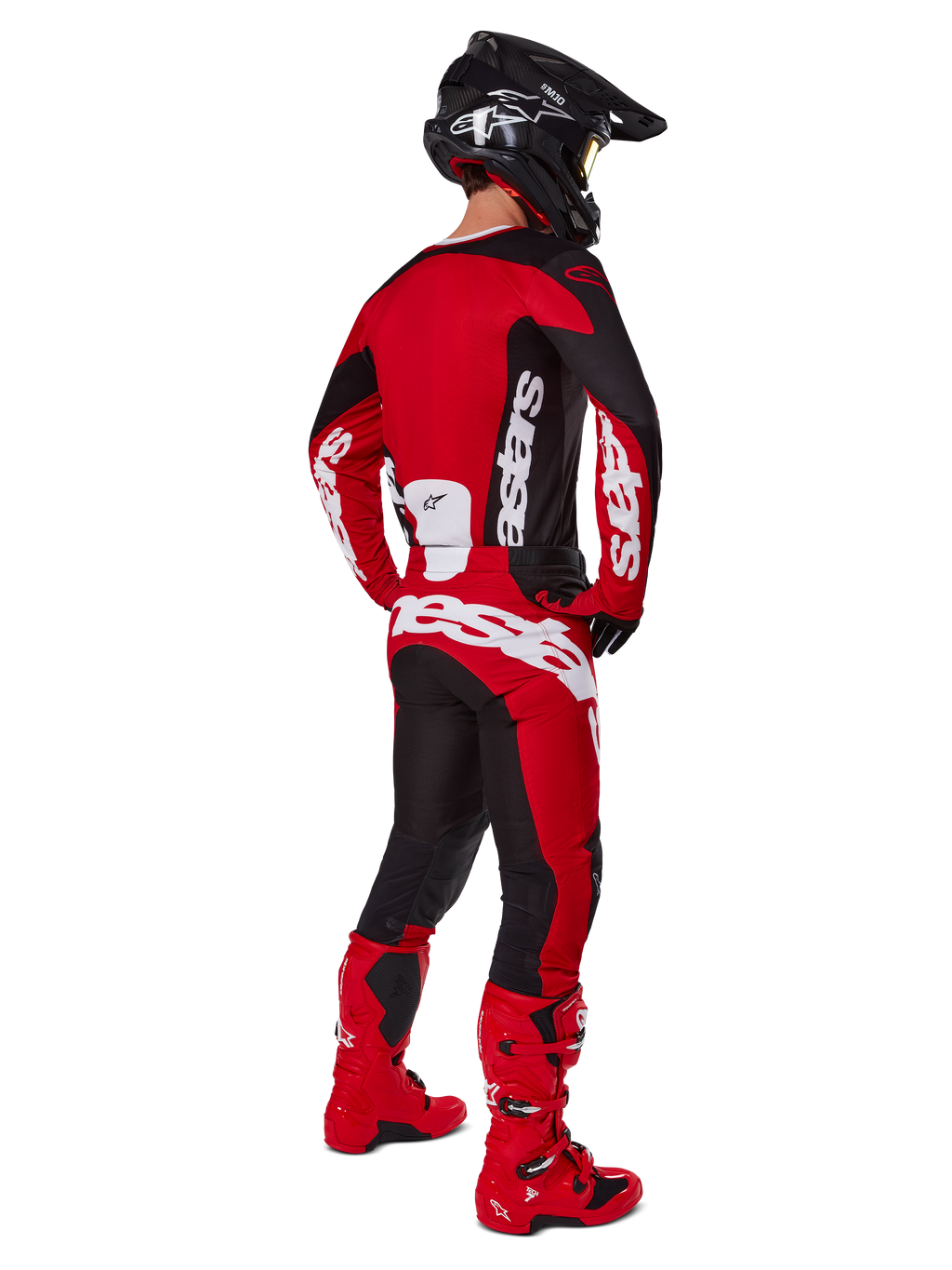 Alpinestars 2025 Racer Veil Gear Set, motocrossrijder van achteren gezien in een rood shirt met zwarte panelen en witte logo's, bijpassende rode en zwarte broek met grote witte merklogo's, rode laarzen en een zwarte helm, complete off-road race-outfit