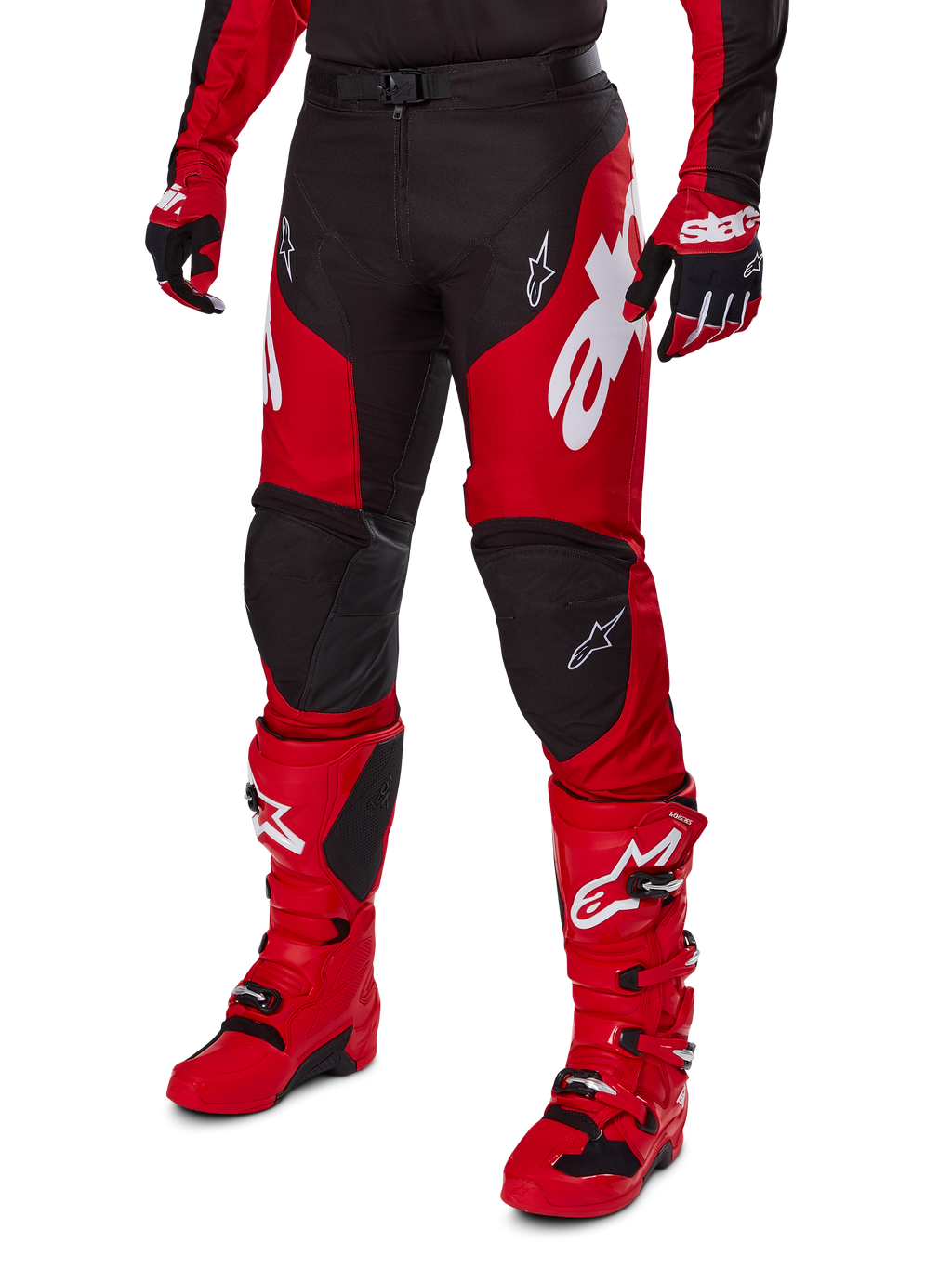 Motorcrosser in Alpinestars 2025 Racer Veil Gear Set, rood en zwart jersey en broek met witte logo's, bijpassende handschoenen en felrode motorcrosslaarzen, gecoördineerde prestatiegerichte uitrusting voor off-road racen