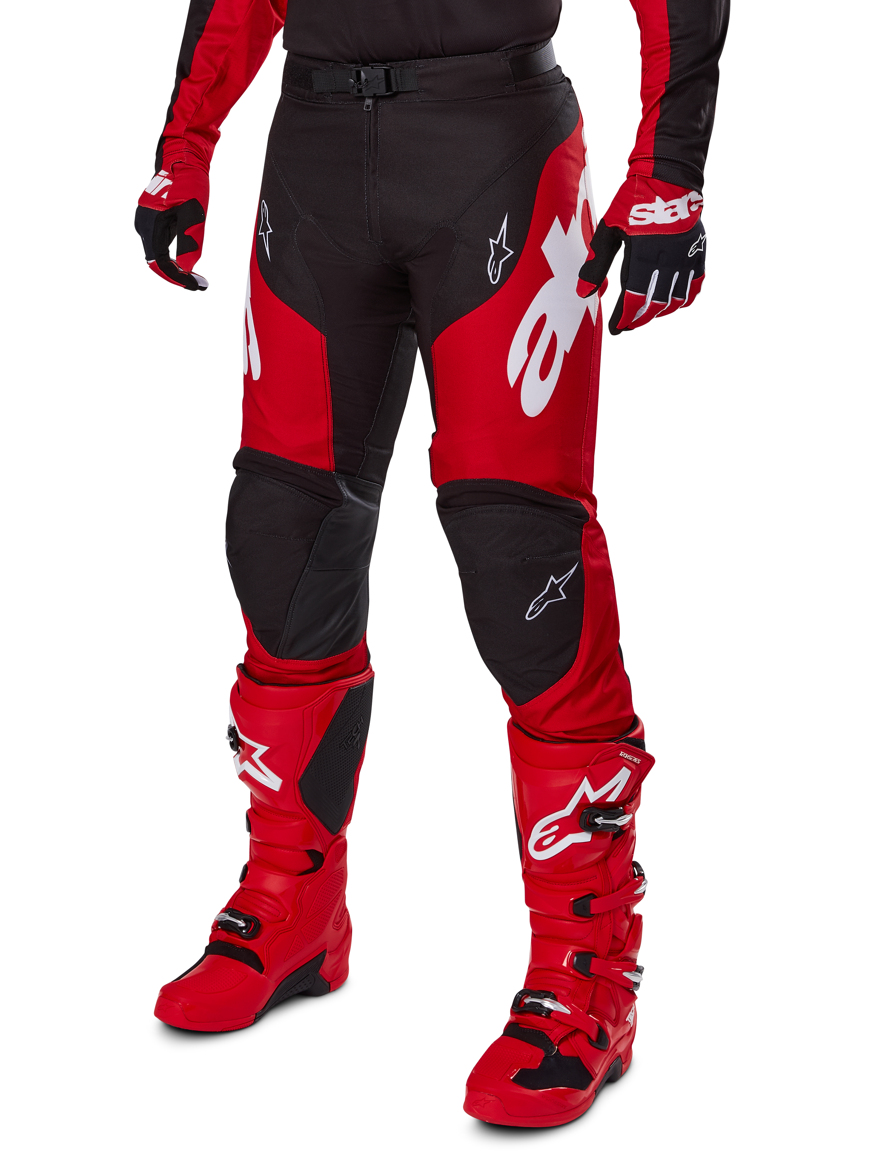 Motorcrosser in Alpinestars 2025 Racer Veil Gear Set, rood en zwart jersey en broek met witte logo's, bijpassende handschoenen en felrode motorcrosslaarzen, gecoördineerde prestatiegerichte uitrusting voor off-road racen