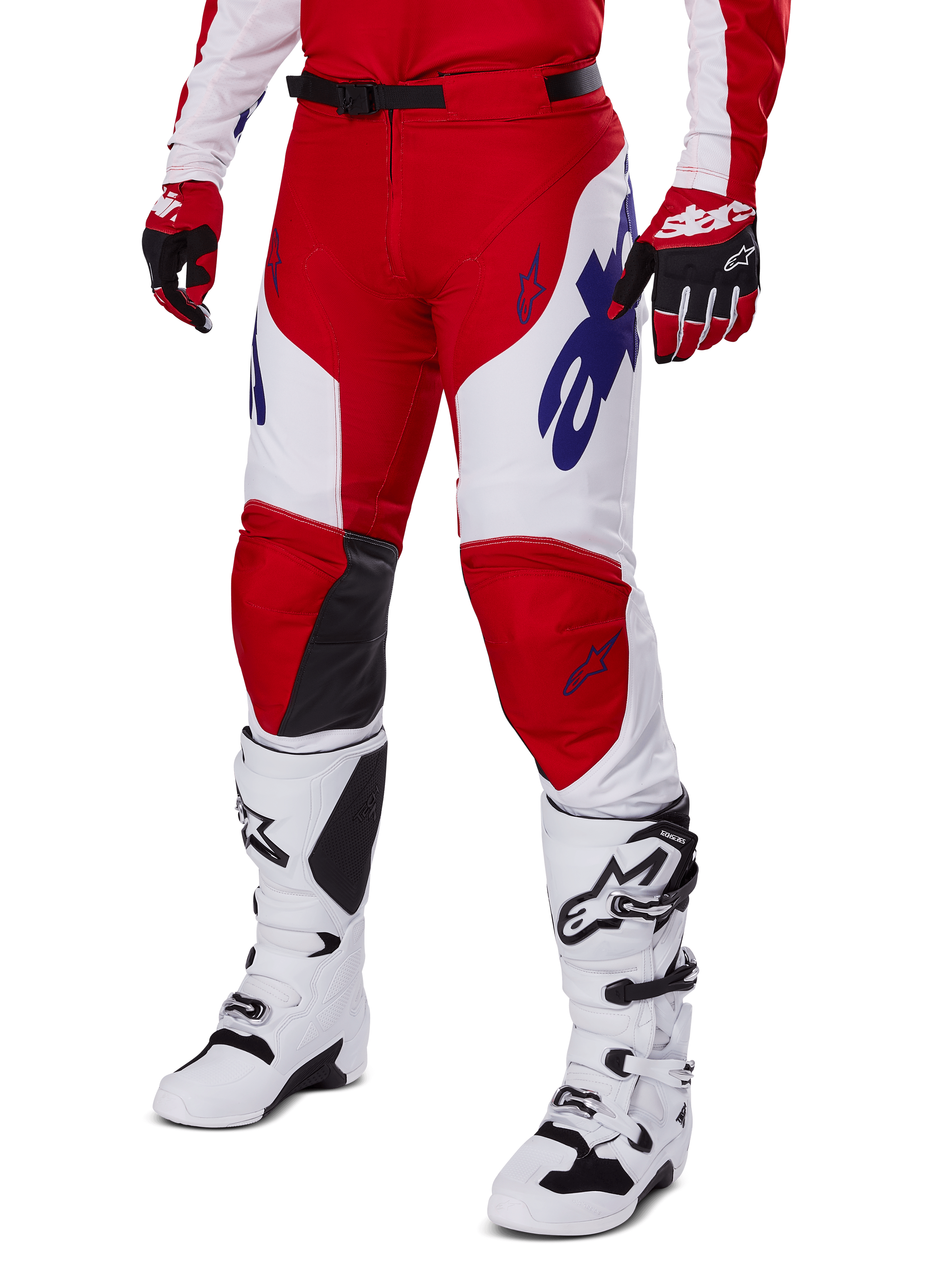 Alpinestars 2025 Racer Veil Pants, motorcrossbroek, helderrood en wit, met blauwe Alpinestars-logo's en zwarte lederen binnenkniepanelen, gedragen met bijpassende rode handschoenen en witte motorcrosslaarzen, gecoördineerde uitrustingsset voor off-road racing