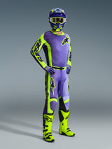 Motorcrosser in Alpinestars 2026 Racer Portl race-uitrusting, paars en neongeel jersey en broek, neongele laarzen, paarse handschoenen en bijpassende helm, volledig gecoördineerde outfit voor off-road motorcrossprestaties.