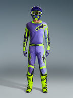 Alpinestars 2026 Racer Portl broek en bijpassende kledingset, motorcrossrijder in paars en neongeel, met een bijpassende jersey, helm, crossbril en felgele laarzen, ontworpen voor off-road prestaties