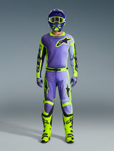 Alpinestars 2026 Racer Portl broek en bijpassende kledingset, motorcrossrijder in paars en neongeel, met een bijpassende jersey, helm, crossbril en felgele laarzen, ontworpen voor off-road prestaties