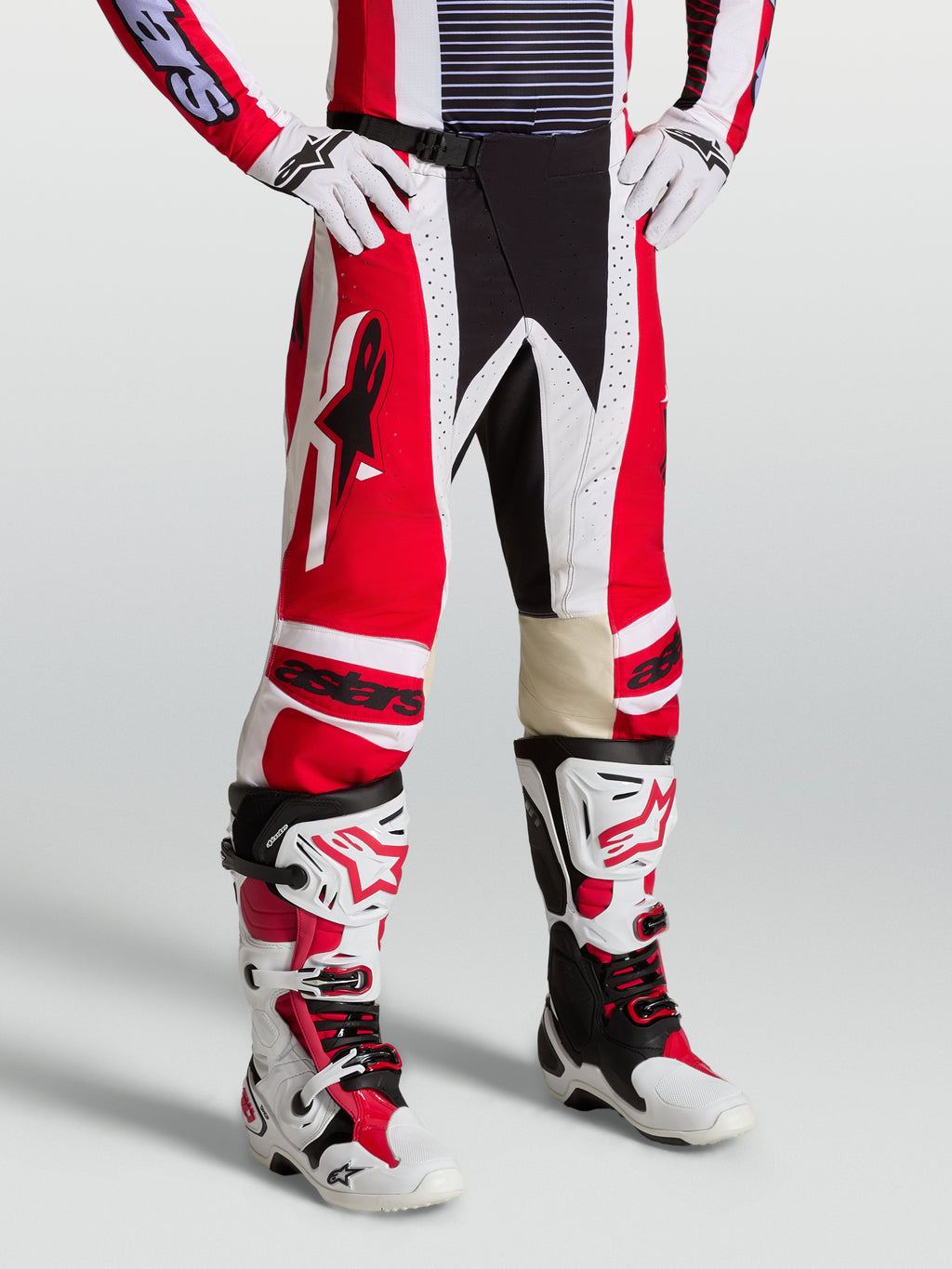 Alpinestars Techstar Maven Broek, heren motocrossuitrusting in rood en wit met lederen kniepanelen en atletische racepasvorm.