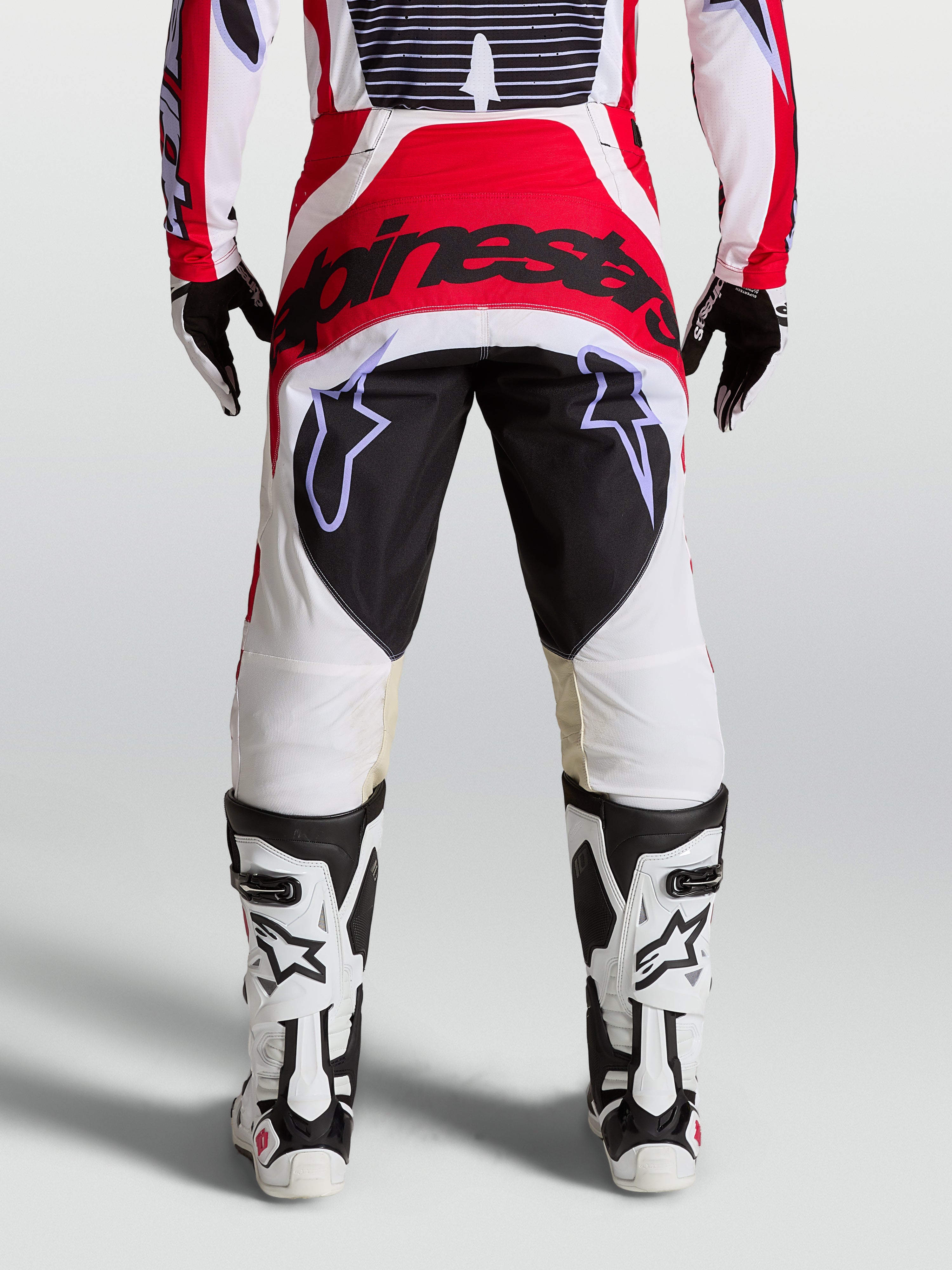 Alpinestars Techstar Maven motocrossbroek in rood, wit en zwart, met een versterkt zitvlak en atletische racepasvorm.