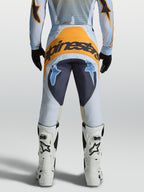 Alpinestars Techstar Maven heren-motocrossbroek, blauw en oranje, 600D polystof, achteraanzicht op rijder.