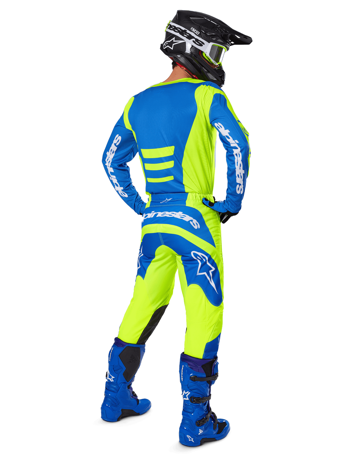 Alpinestars 2025 Fluid Haul broek en bijpassende jersey, motorcrosser van achteren gezien, fluoriserend geel en blauw, gecombineerd met blauwe laarzen en een zwarte Alpinestars helm, professionele off-road race-uitrusting