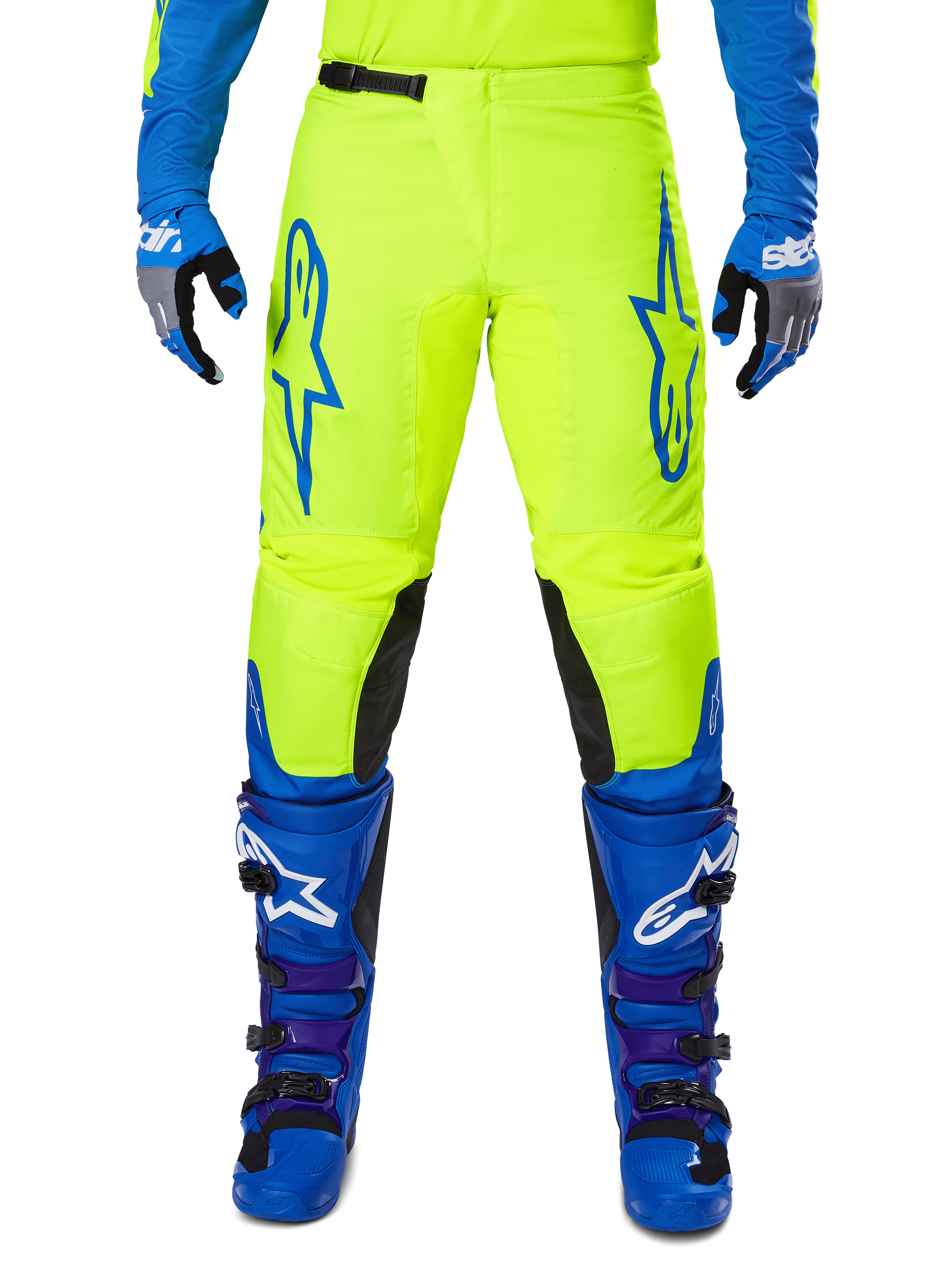 Alpinestars 2025 Fluid Haul motorcrossbroek, felgeel en blauw, gedragen met bijpassende handschoenen en laarzen, zwarte panelen aan de binnenkant van de knieën, opvallende blauwe logo's op de dijen, sportief ergonomisch ontwerp