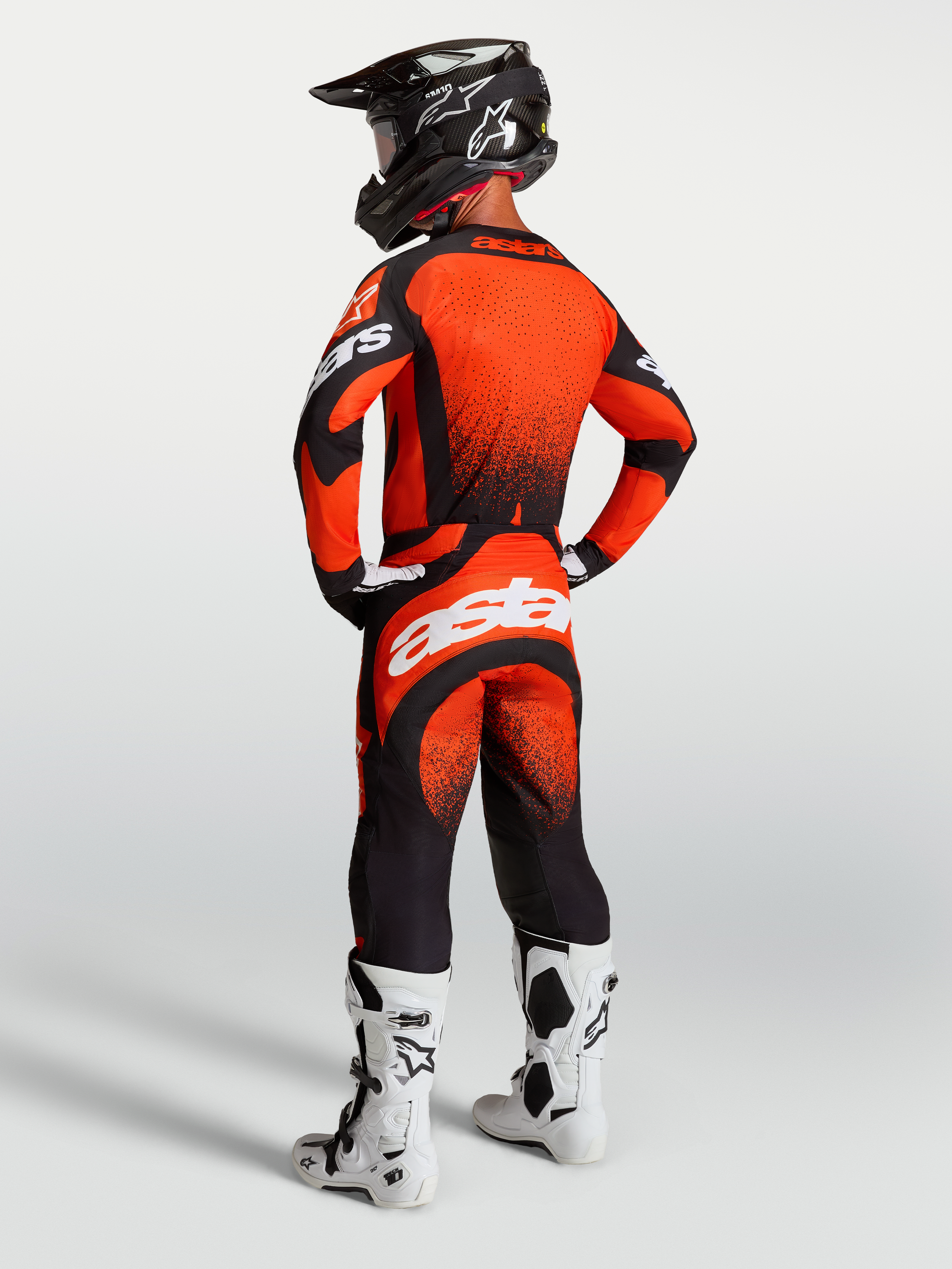 Alpinestars Techstar Swan broek en jersey, motorcross-race-outfit in rood en zwart met witte branding, achteraanzicht.