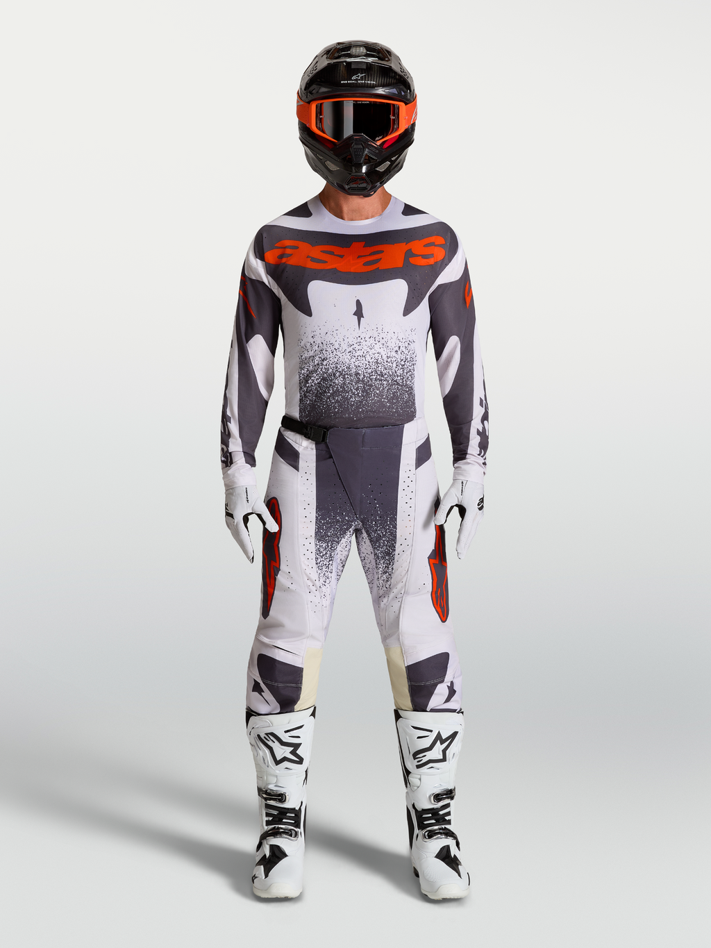 Alpinestars Techstar Swan broek, heren motocross-set in licht lila, donkergrijs en fluorood met witte motorlaarzen.