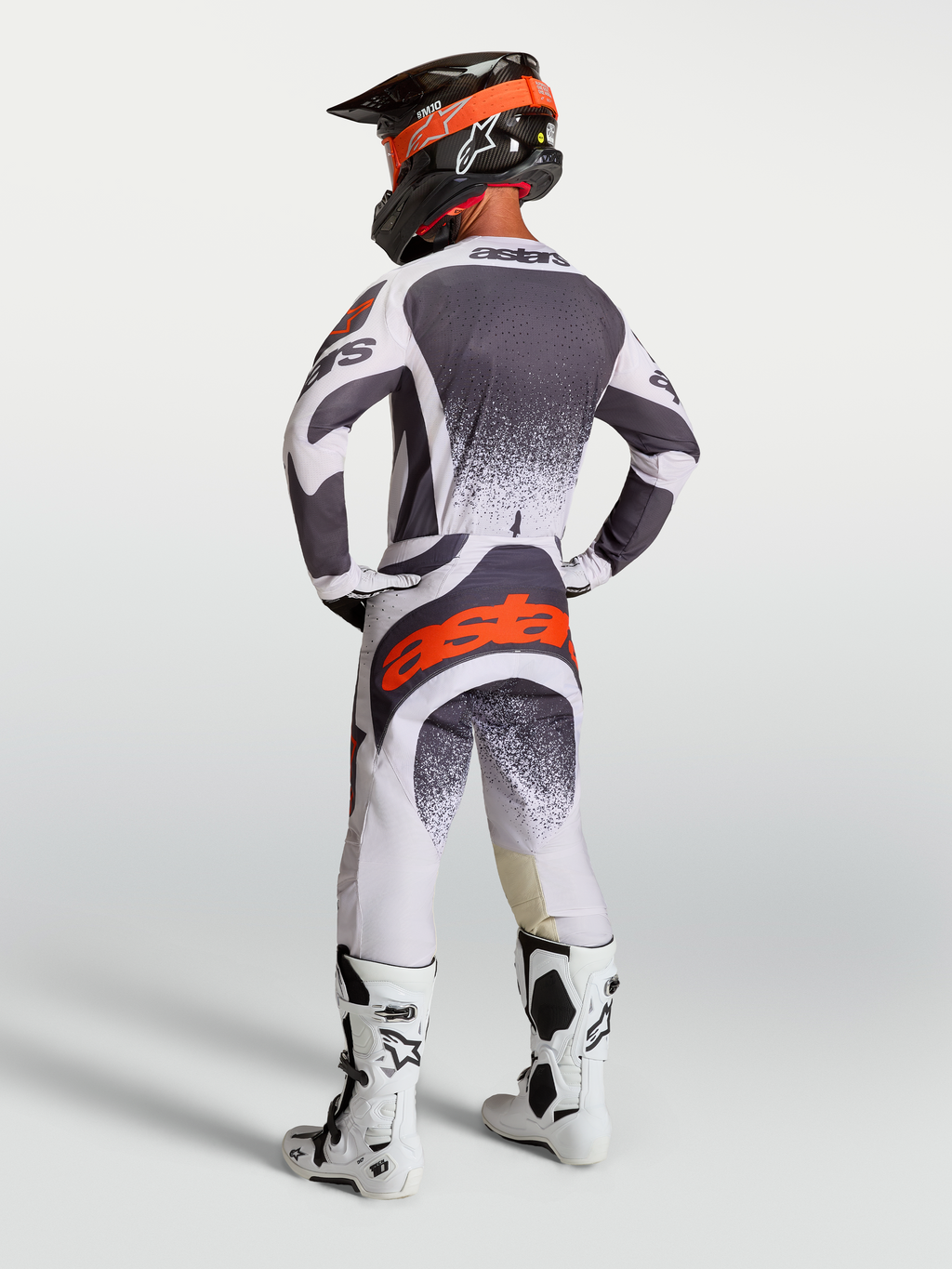 Alpinestars Techstar Swan broek en jersey, heren motorcrossuitrusting in grijs, wit en rood fluo, achteraanzicht op model.