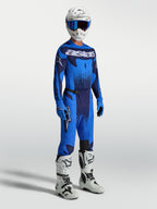Alpinestars Techstar Swan broek, heren motocrossbroek in blauw en donkerblauw, met bijpassende jersey en witte motorlaarzen.