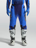 Alpinestars Techstar Swan broek, blauwe heren motocrossbroek met geperforeerde stretchpanelen en witte motorlaarzen.