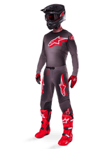 Alpinestars 2025 Supertech Lipan Pants, Motocross Pants, Smoke Bright Red, dark grey base with large red Alpinestars logos on the thighs, worn with matching jersey, black helmet, red and black gloves, and bright red boots, coordinated pro-level motocross outfit