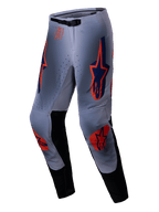 Alpinestars 2025 Supertech Lipan crossbroek, motorcrossbroek, grijs en oranje fluo, met opvallende oranje en marineblauwe sterlogo's op de dijen en knieën, zwarte binnenbeenpanelen en een verstelbare tailleband, ontworpen voor professionele off-road prestaties.