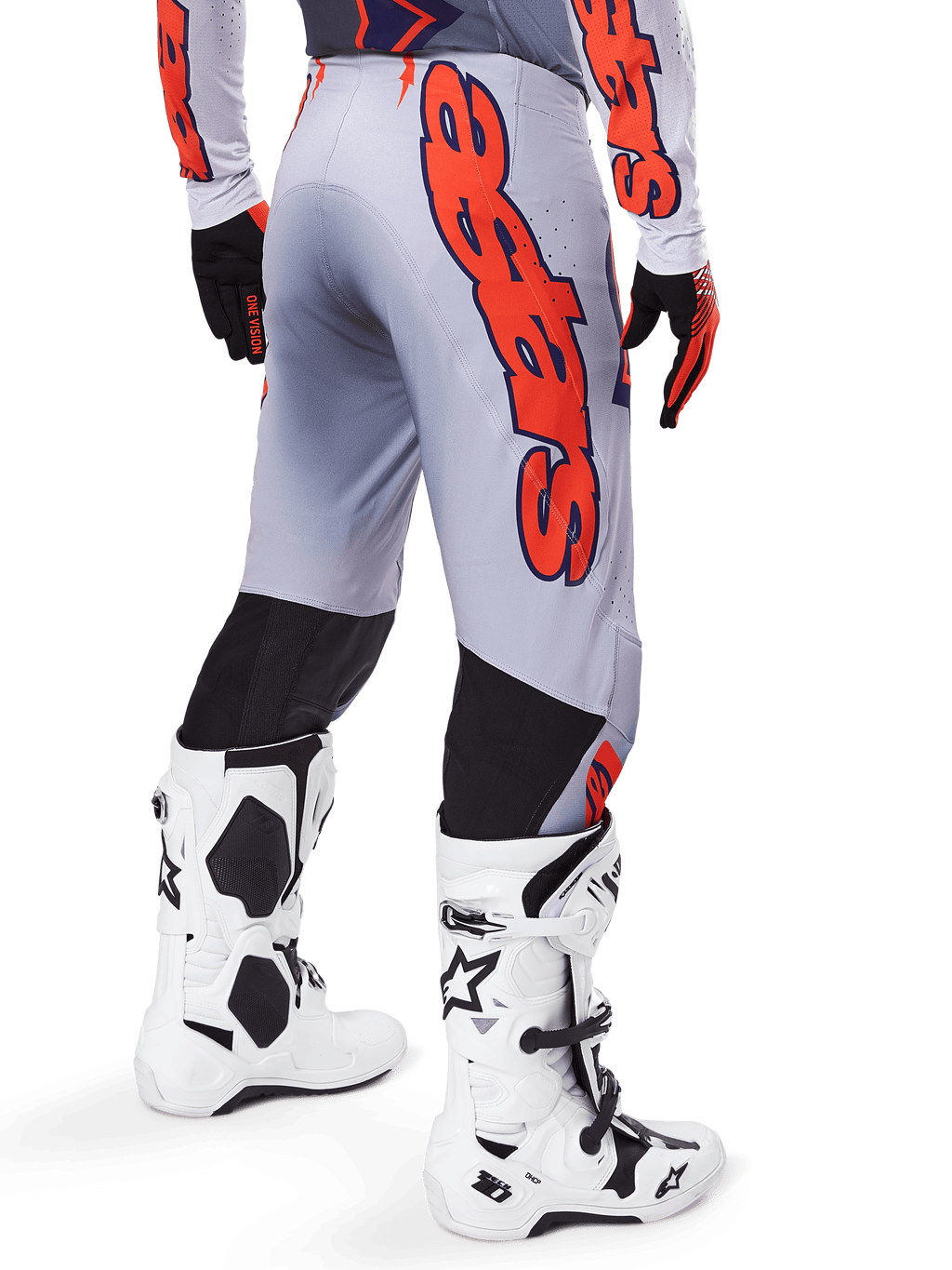 Alpinestars 2025 Supertech Lipan crossbroek, motorcrossbroek, grijs en fluoranje, gedragen met bijpassende jersey en witte laarzen, achteraanzicht met grote oranje Alpinestars grafische branding, zwarte stretchpanelen, professionele motorcrossuitrusting