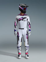 Motorcrossrijder met een complete race-uitrusting, Alpinestars 2026 Supertech AFD Vista broek en jersey in wit, paars en zwart, bijpassende handschoenen, witte en zwarte laarzen, zwarte helm met paarse bril, strakke atletische pasvorm voor off-road prestaties